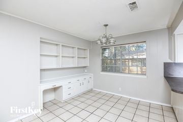 Arlington house for rent - a kitchen with white cabinets and a desk and a window