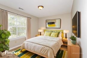 Memphis house for rent - A bedroom with a large bed and a flat screen TV mounted on the wall.