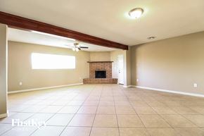 Mesa house for rent - A spacious living room with a fireplace and a ceiling fan.
