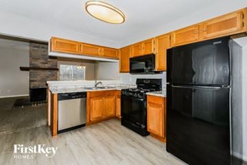 Houston house for rent - A kitchen with wooden cabinets and black appliances.