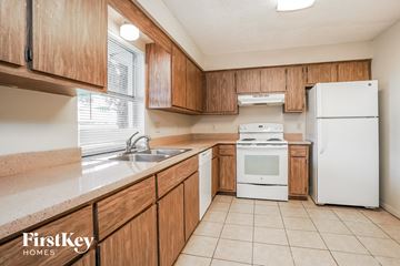 Fort Myers house for rent - A kitchen with wooden cabinets and white appliances.