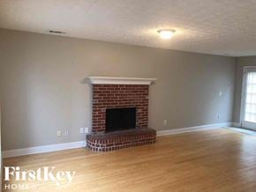 Lawrenceville house for rent - A room with a fireplace and wooden floors.