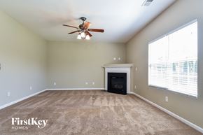 Kernersville house for rent - an empty living room with a fireplace and a ceiling fan