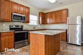 Kernersville house for rent - a kitchen with wooden cabinets and stainless steel appliances