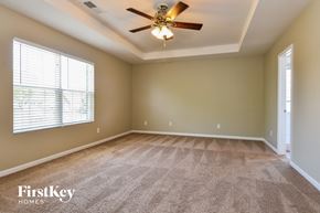 Kernersville house for rent - an empty living room with a ceiling fan and a large window