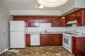 Elgin house for rent - an empty kitchen with white appliances and wooden cabinets