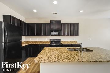 Mcdonough house for rent - a kitchen with black appliances and granite counter tops