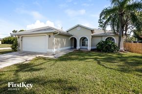 Fort Myers house for rent - a house with a lawn and a palm tree
