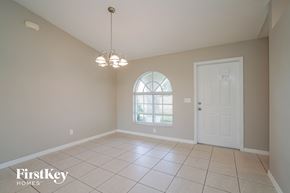 Fort Myers house for rent - an empty dining room with a white door and a window