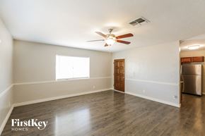 Phoenix house for rent - an empty living room with a ceiling fan and a kitchen