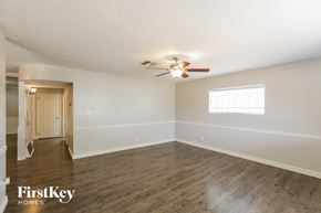 Phoenix house for rent - an empty living room with white walls and a ceiling fan