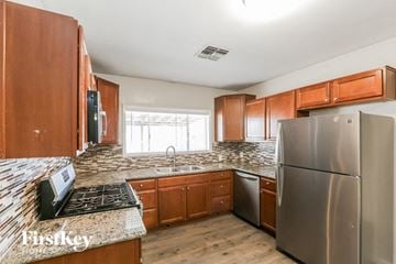 Phoenix house for rent - a kitchen with wooden cabinets and stainless steel appliances