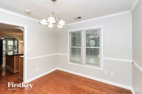 Acworth house for rent - an empty dining room with a large window and wood flooring
