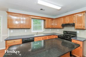 Acworth house for rent - a kitchen with wooden cabinets and a black counter top