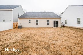 Gastonia house for rent - a backyard with a white house and a yard with brown grass