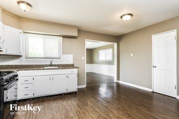 Florissant house for rent - A kitchen with white cabinets and a wooden floor.
