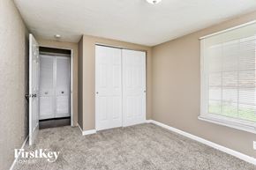 Florissant house for rent - A bedroom with a white door and a grey carpet.