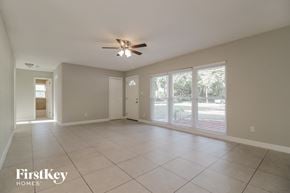 Winter Park house for rent - an empty living room with large windows and a ceiling fan