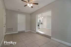 Winter Park house for rent - an empty living room with a ceiling fan and a kitchen