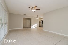 Winter Park house for rent - an empty living room with a ceiling fan and tiled floor
