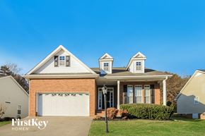 Winston-Salem house for rent - a brick house with a white garage door and a lawn