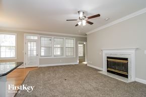 Winston-Salem house for rent - a living room with a fireplace and a ceiling fan