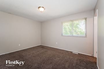 Florissant house for rent - the living room of a small white house with carpet and a window