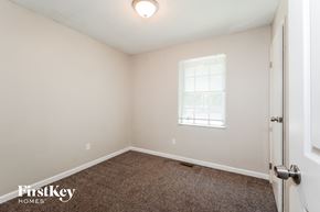 Florissant house for rent - a bedroom with a carpeted floor and a window