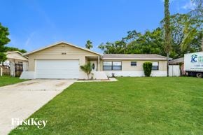 Orlando house for rent - A house with a garage and a driveway in front of it.