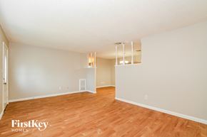 Orlando house for rent - A room with wooden floors and white walls, with a light fixture hanging from the ceiling.