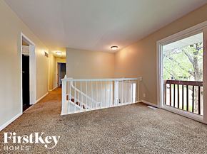 Aurora house for rent - the upstairs loft has a large window and a white staircase