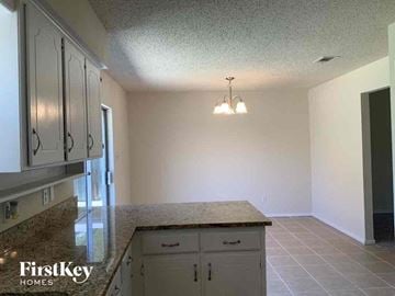 Lewisville house for rent - a kitchen with white cabinets and a counter top