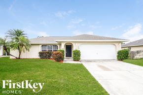 Fort Myers house for rent - A house with a garage and a driveway in front of it.