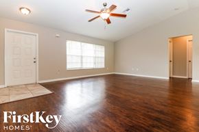 Fort Myers house for rent - A spacious room with a ceiling fan and wooden flooring.