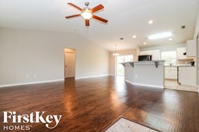 Fort Myers house for rent - A spacious room with a ceiling fan and wooden flooring.