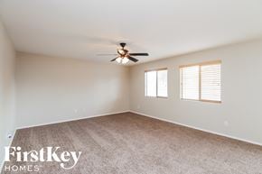 San Tan Valley house for rent - an empty living room with a ceiling fan and window