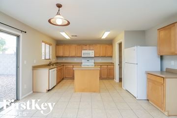 San Tan Valley house for rent - a large kitchen with white appliances and wooden cabinets