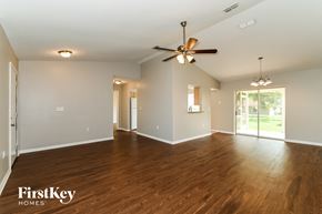 Fort Myers house for rent - an empty living room with wood floors and a ceiling fan