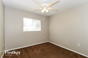 Fort Myers house for rent - a bedroom with a carpeted floor and a ceiling fan