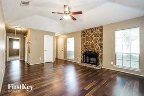 Cypress house for rent - A spacious living room with wood flooring and a stone fireplace.