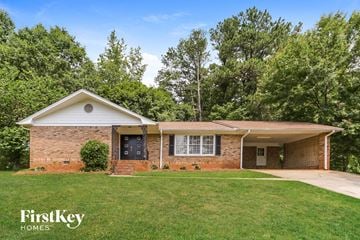 Austell house for rent - a brick house with a green lawn and trees