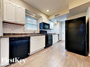 Homewood house for rent - a kitchen with black appliances and white cabinets