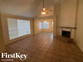 Katy house for rent - A living room with a fireplace and a tiled floor.