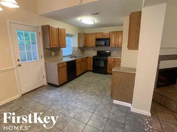 Katy house for rent - A kitchen with wooden cabinets and a tiled floor.