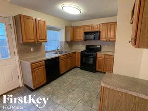Katy house for rent - A kitchen with wooden cabinets and a black stove top oven.