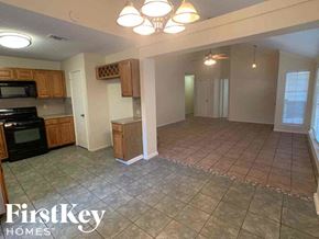 Katy house for rent - A kitchen with a black stove top oven and a black microwave.