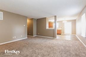 Indianapolis house for rent - an empty living room with carpet and a kitchen