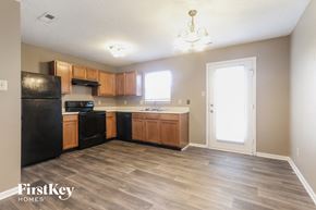 Indianapolis house for rent - a kitchen with wood flooring and wooden cabinets and black appliances