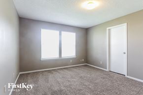 Indianapolis house for rent - a bedroom with a carpeted floor and two windows