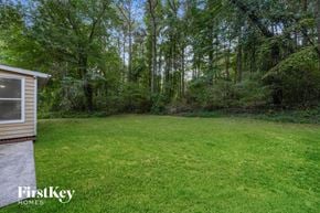 Loganville house for rent - A backyard with a grassy area and a shed.